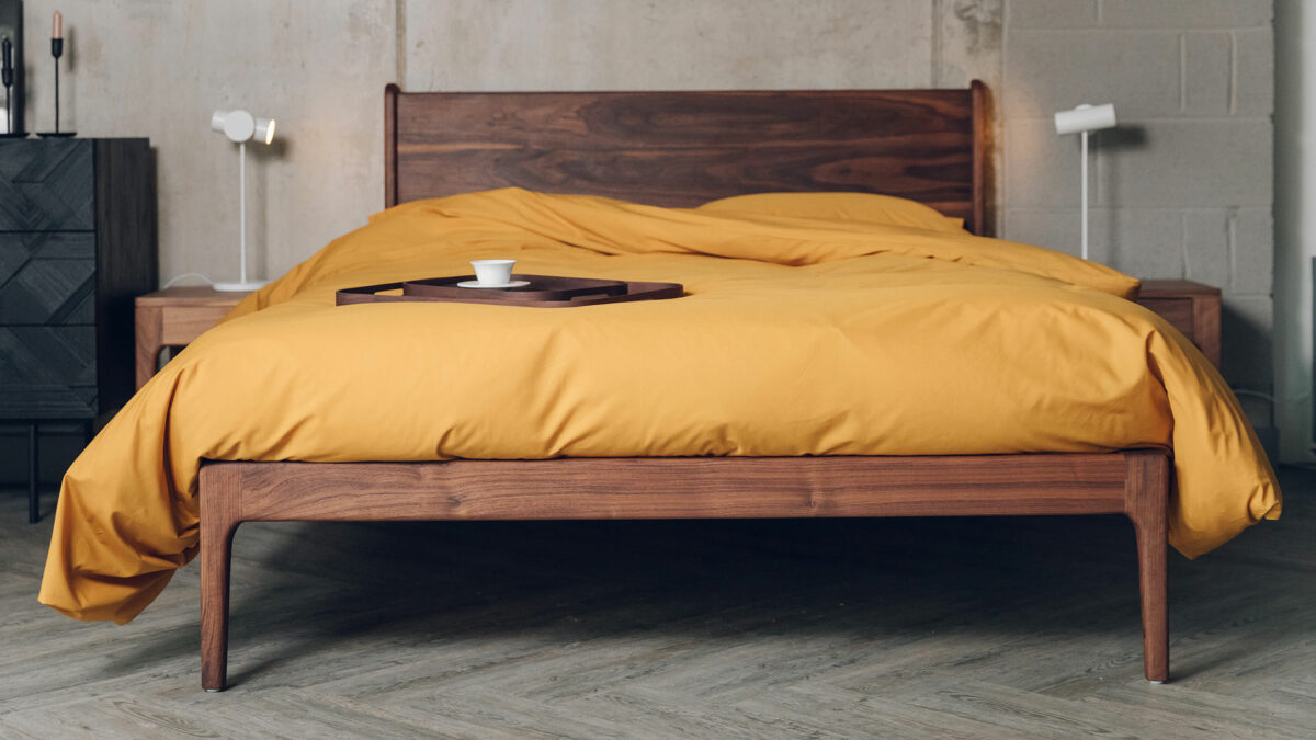 rich ochre colour cotton duvet set shown on a deep oiled walnut wood Camden bed