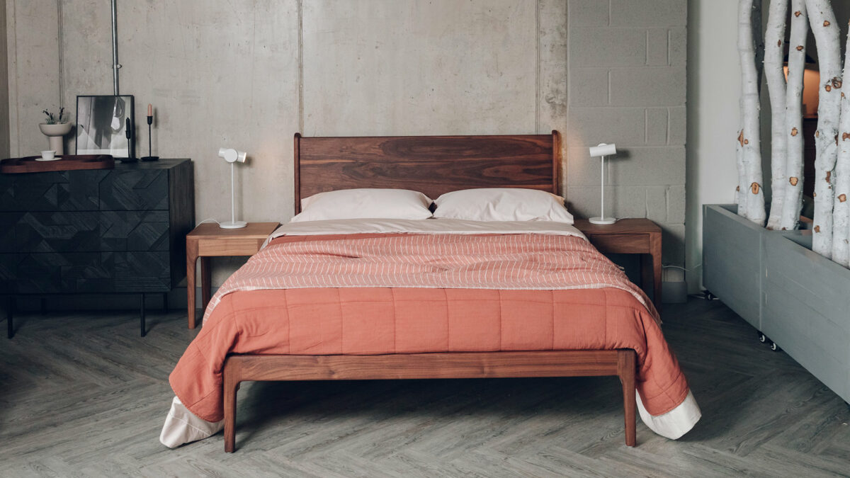 an oiled finish rich walnut Camden bed in Kingsize shown with terracotta quilted bedspread and shell cotton bedding