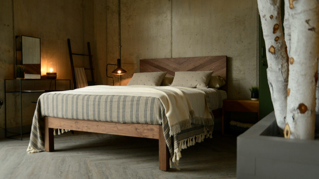 Chunky solid wood handmade Hathersage bed in walnut, shown in an industrial style bedroom