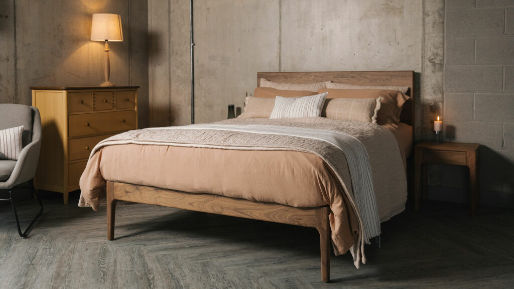 bedspread and pillowcase set in Blush pink shown with clay coloured muslin like bedding shown on a kingsize walnut bed