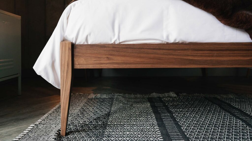 a closer view of the Dalston bed's tapering legs shown in walnut wood