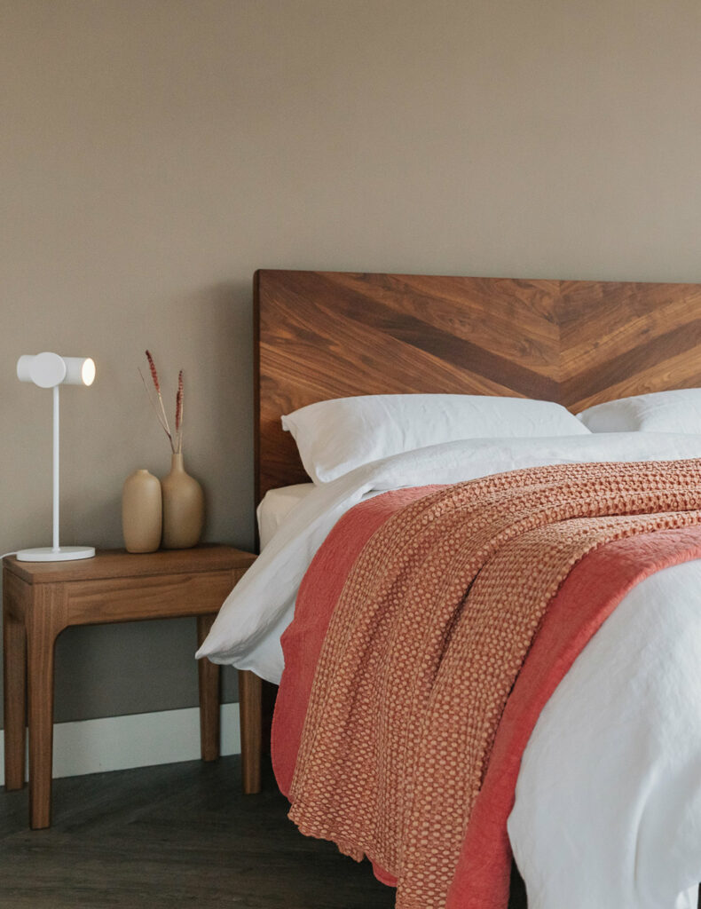 Statement making Walnut Hathersage bed with chevron pattern headboard and coral coloured bedspreads