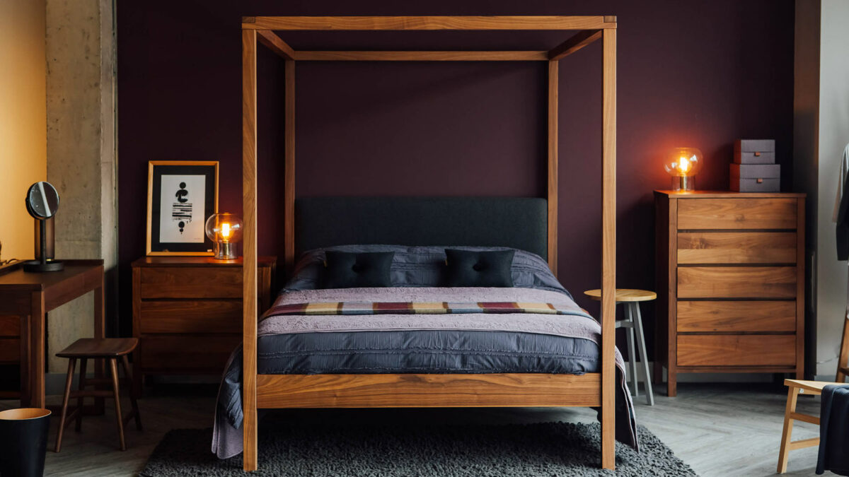 Autumnal bedroom with berry coloured wall, Walnut Highland 4 poster bed, and walnut drawers