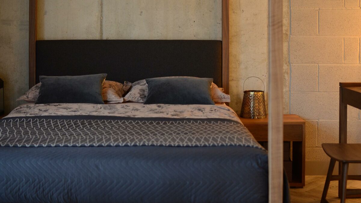 Blush pink and grey bedding with contemporary wooden 4 poster bed with upholstered headboard