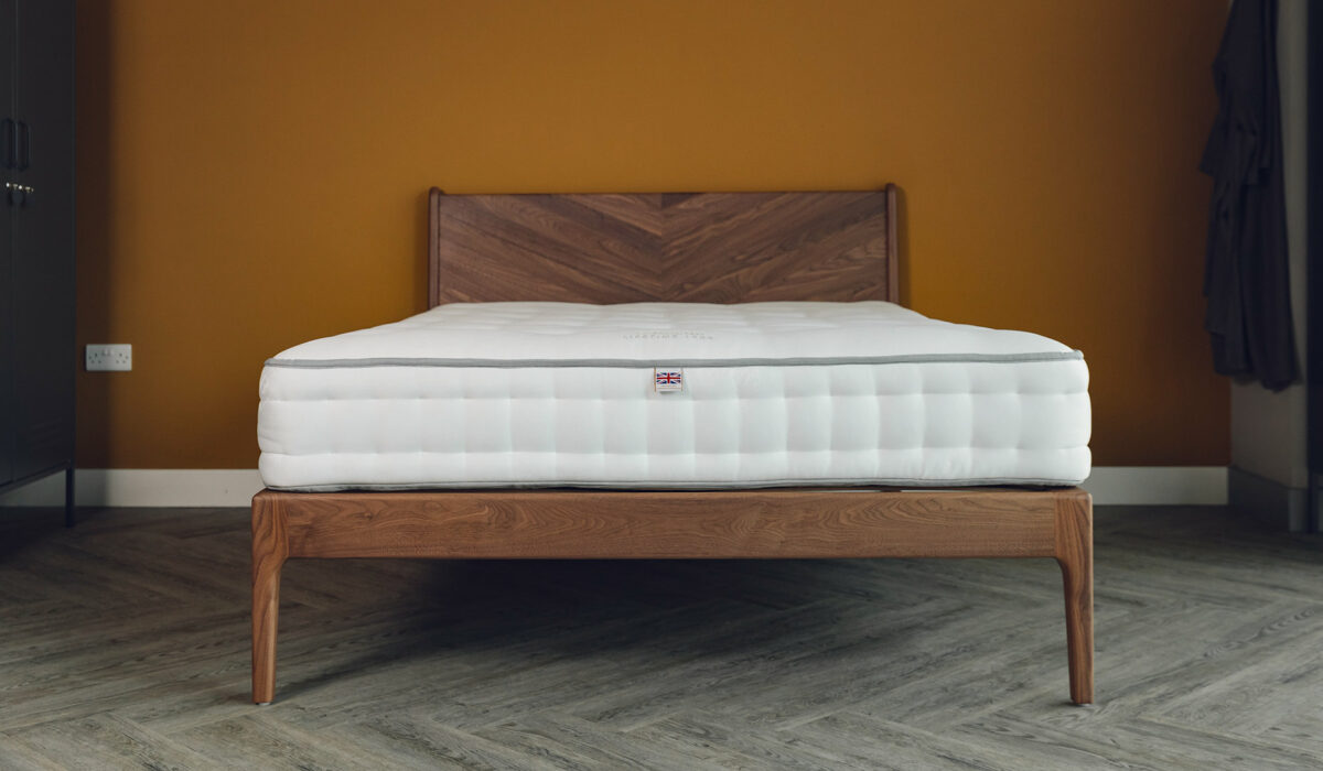 A kingsize walnut Hoxton bed with chevron pattern headboard shown without bedding