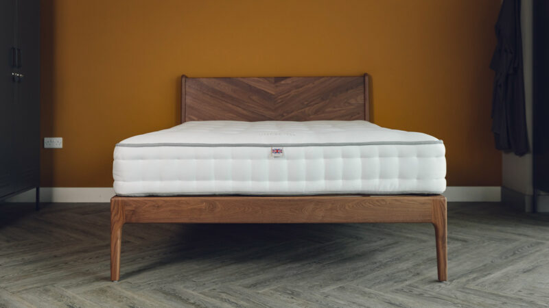 A kingsize walnut Hoxton bed with chevron pattern headboard shown without bedding