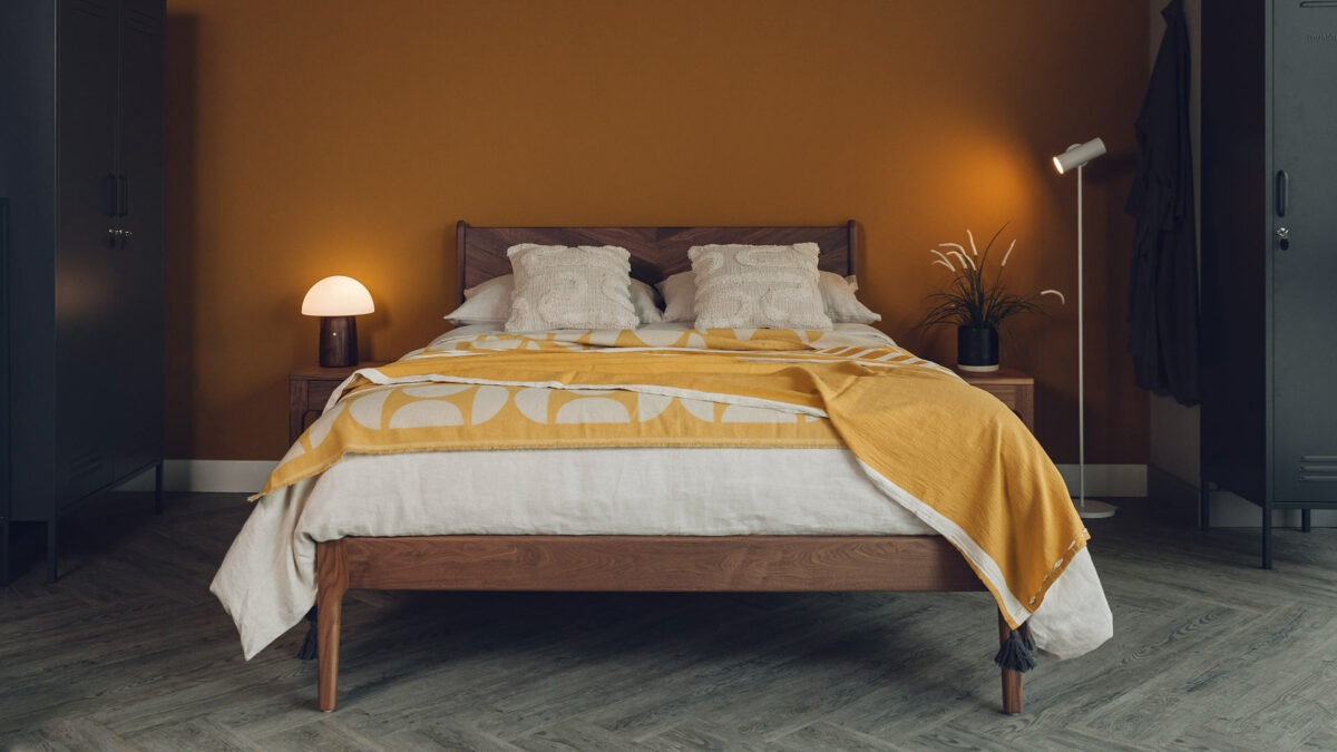 A luxurious modern Boho look with a walnut Hoxton bed, ecru bedding and ochre and ivory light bedspreads