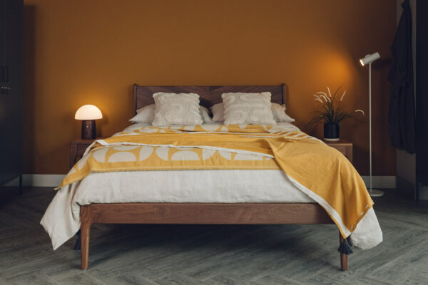 walnut hoxton bed with ochre and ecru bedding and mushroom lamp