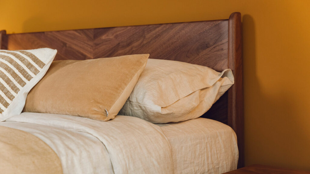 The Hoxton bed has a chevron pattern solid wood headboard here shown in walnut