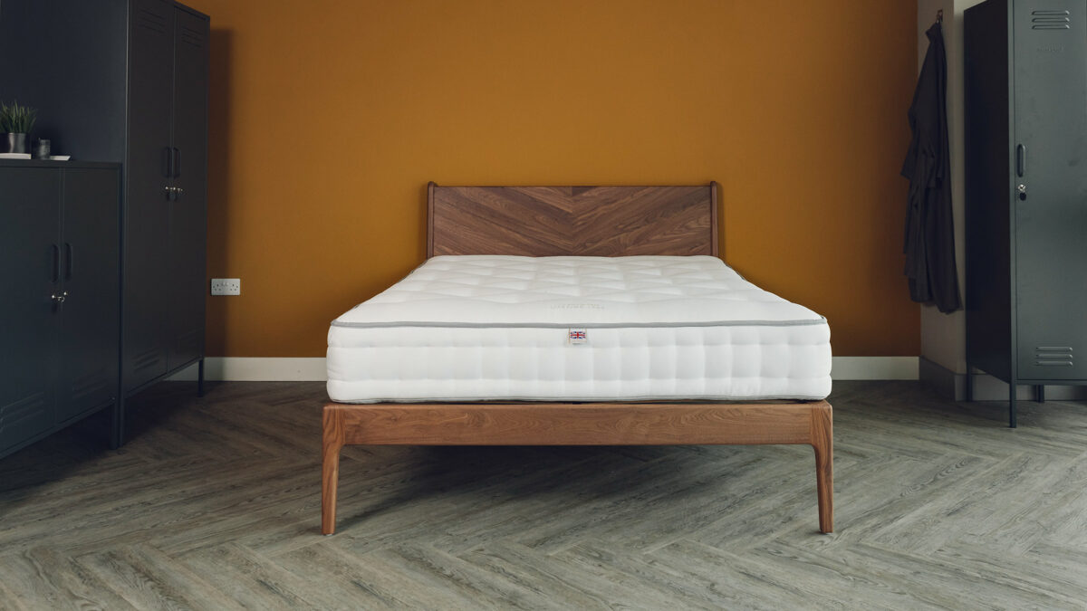 Hand made walnut Hoxton bed with chevron pattern headboard shown without bedding