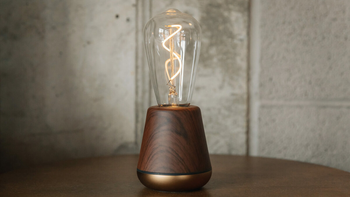 chargeable and portable modern bulb light in walnut wood with a brass metallic base