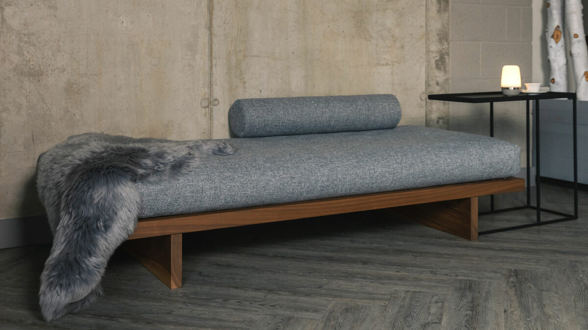 walnut kyoto daybed with grey mattress and long haired sheepskin
