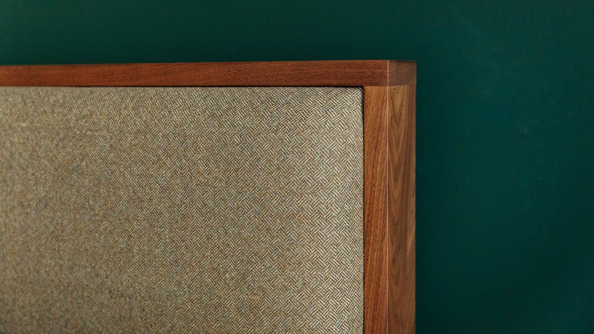 close up view of the Shetland headboard in walnut wood with parquet weave wool upholstery