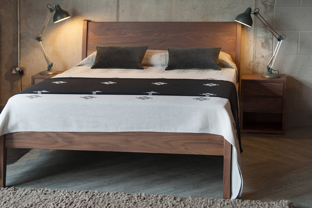 Cube bedside table shown with wooden Zanskar bed all in Walnut.