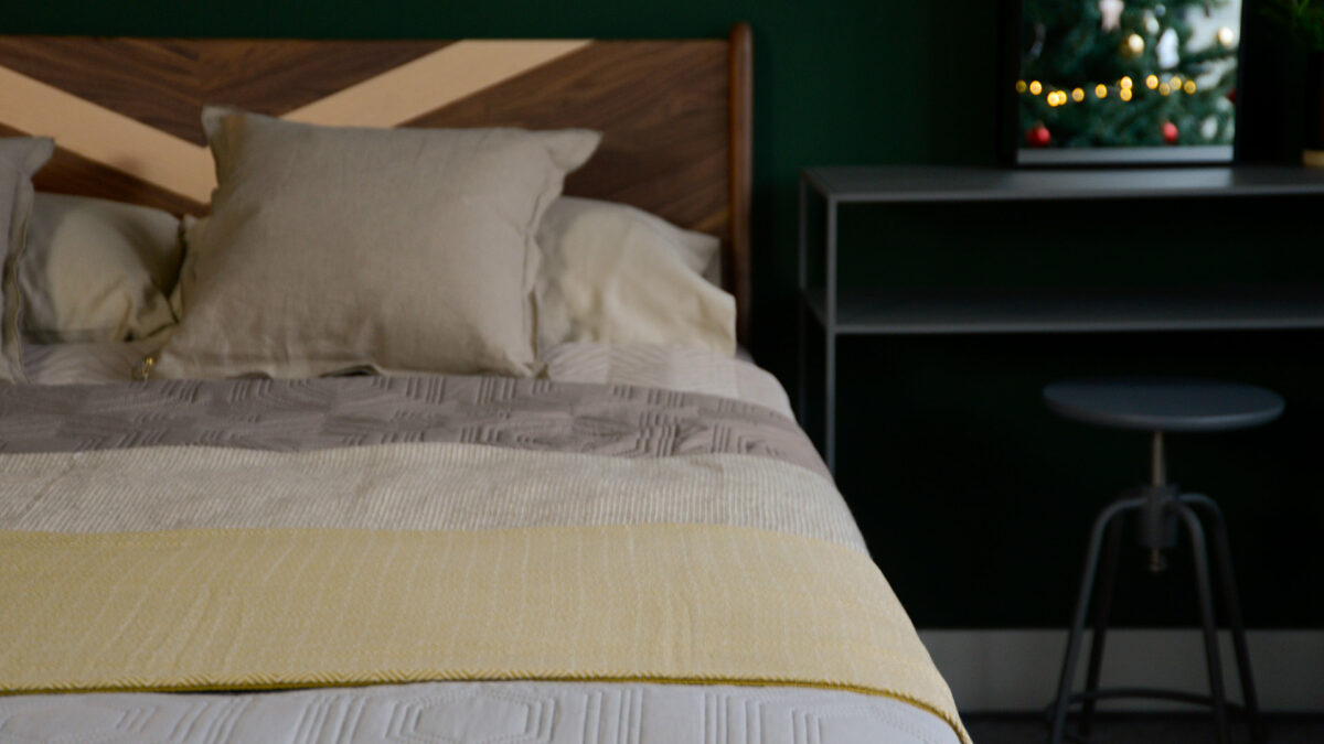 cotton blanket in chartreuse shown over solid wood Hoxton bed