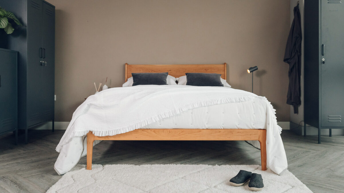 monochrome bedroom style with dark grey lockers white bedding and a rich toned cherry wood Camden bed