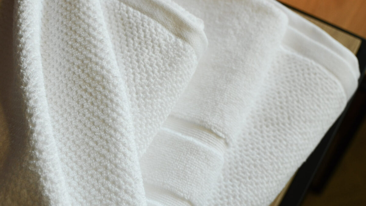 white cotton towels bath mats stack