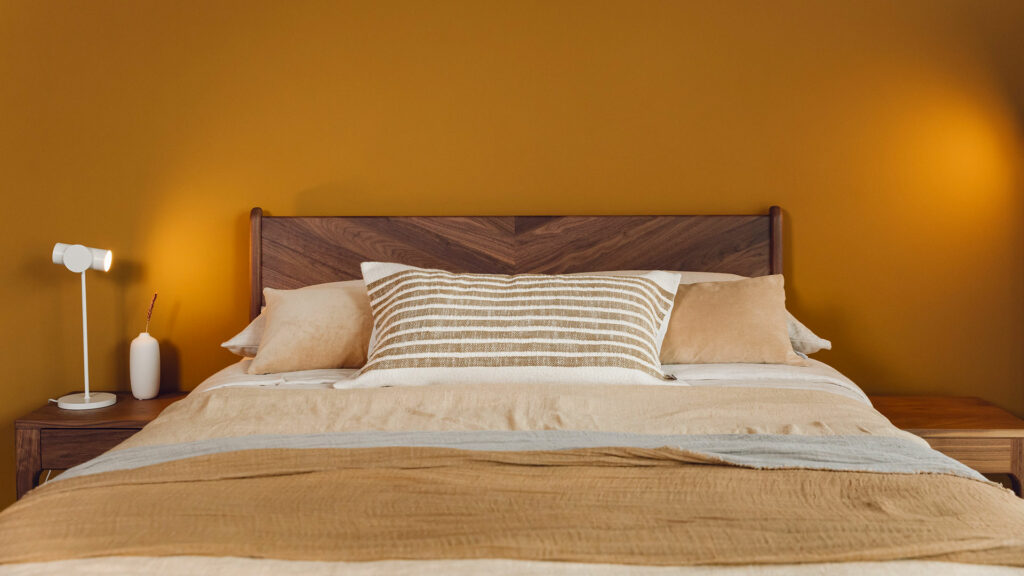 The Hoxton bed has a chevron pattern solid wood headboard here shown in walnut