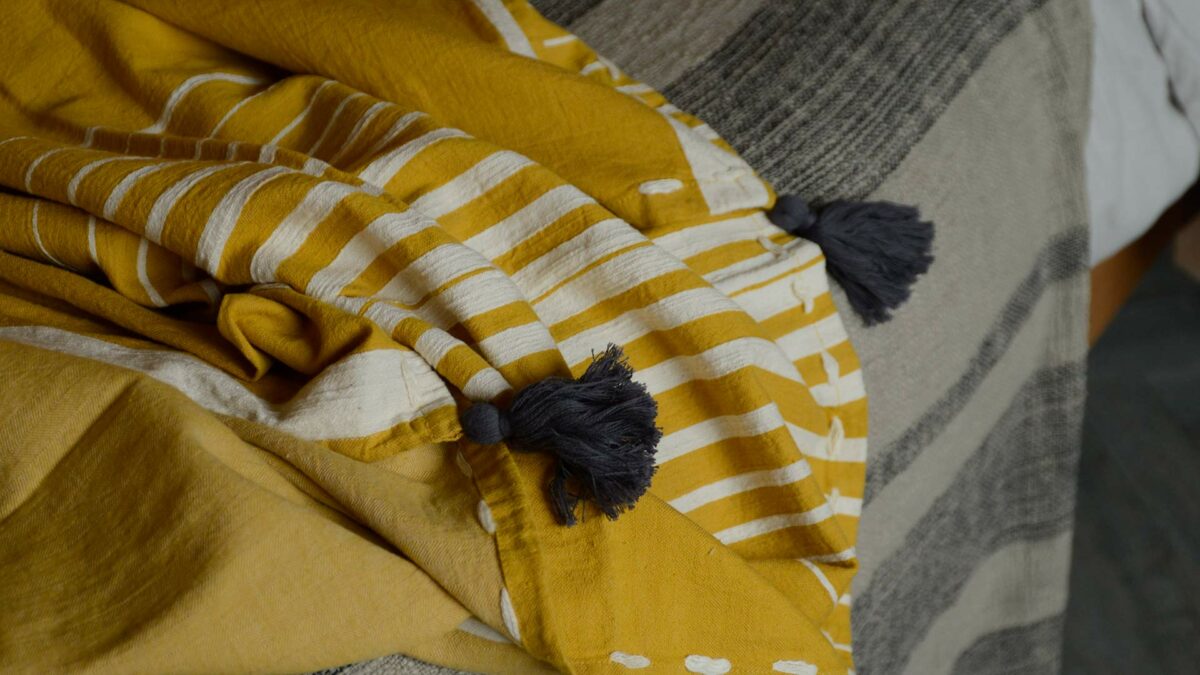 deep yellow cotton throw with printed ivory stripe and grey tassel